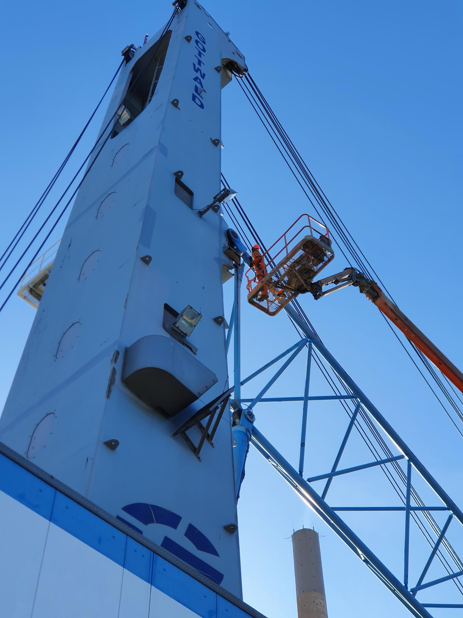 Team member servicing a crane, on an EWP